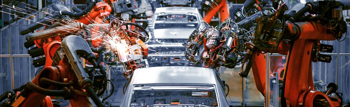 Steel body structures on a vehicle assembly line being welded by robots