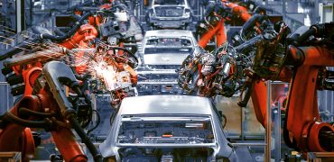 Steel body structures on a vehicle assembly line being welded by robots